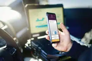 Police officer using a language interpreter app on his smartphone for real-time translation.