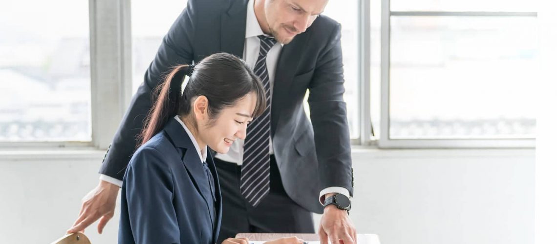 Two colleagues in an office using language interpretation services to discuss and translate information during a business meeting.
